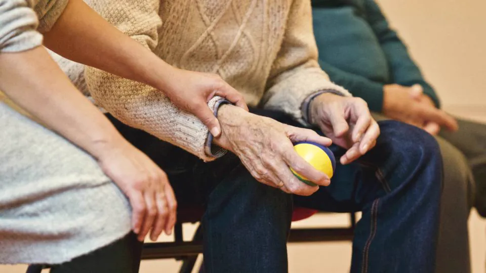Manos de varias personas compartiendo una actividad sobre una mesa.